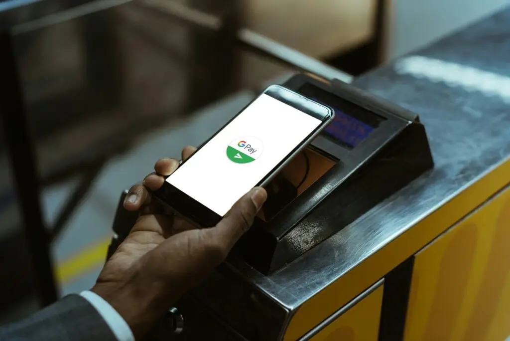 Close-up view of businessman using Google Pay paying for public transport